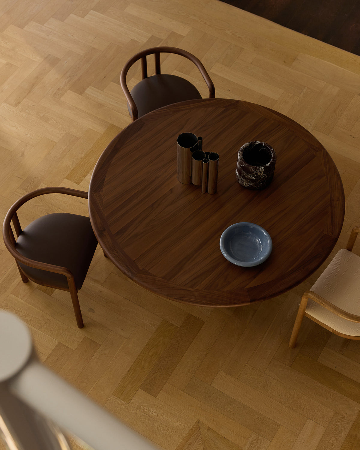 Walnut round dining table with dining chairs and decor
