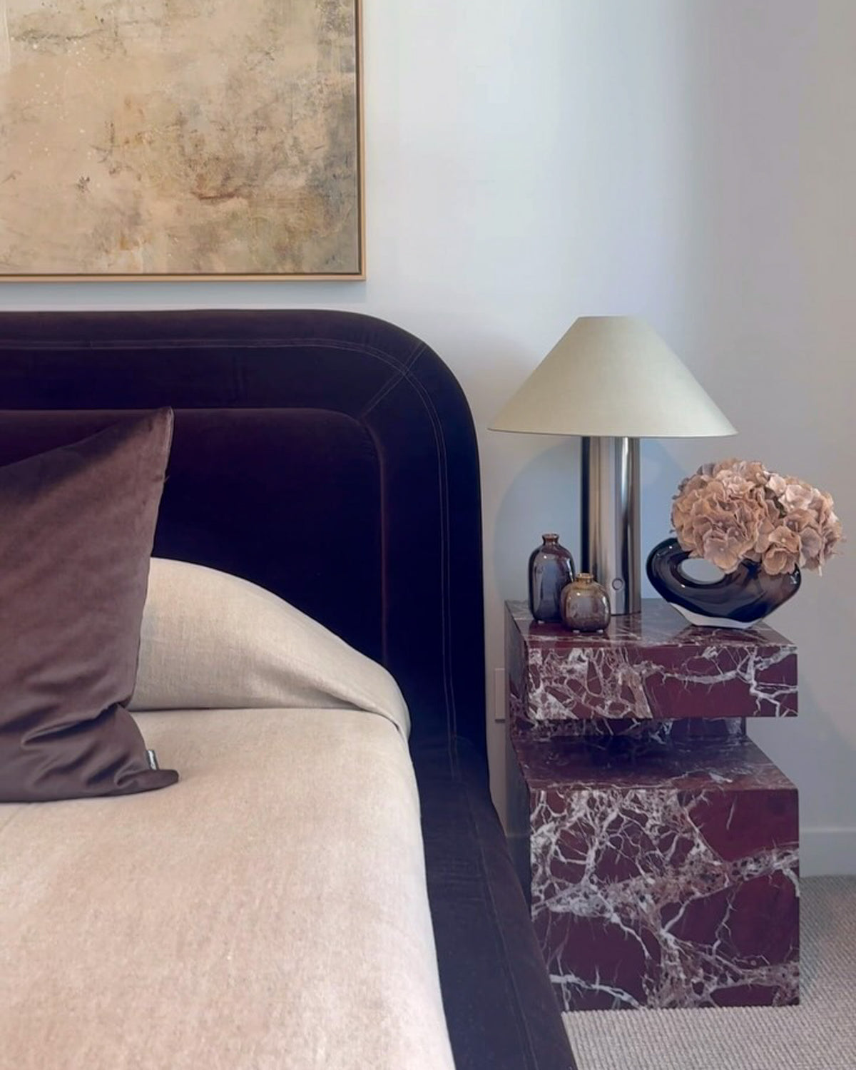 A styled bedroom with a marble side table