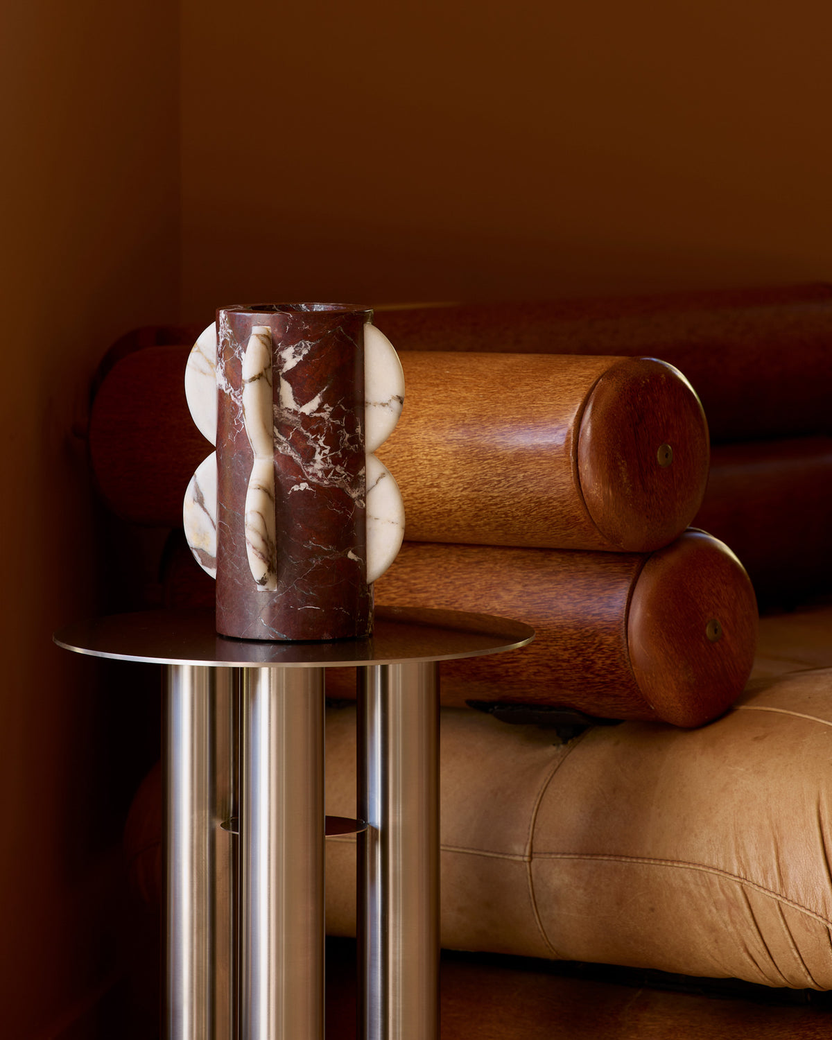 A cylindrical marble vase placed on a side table