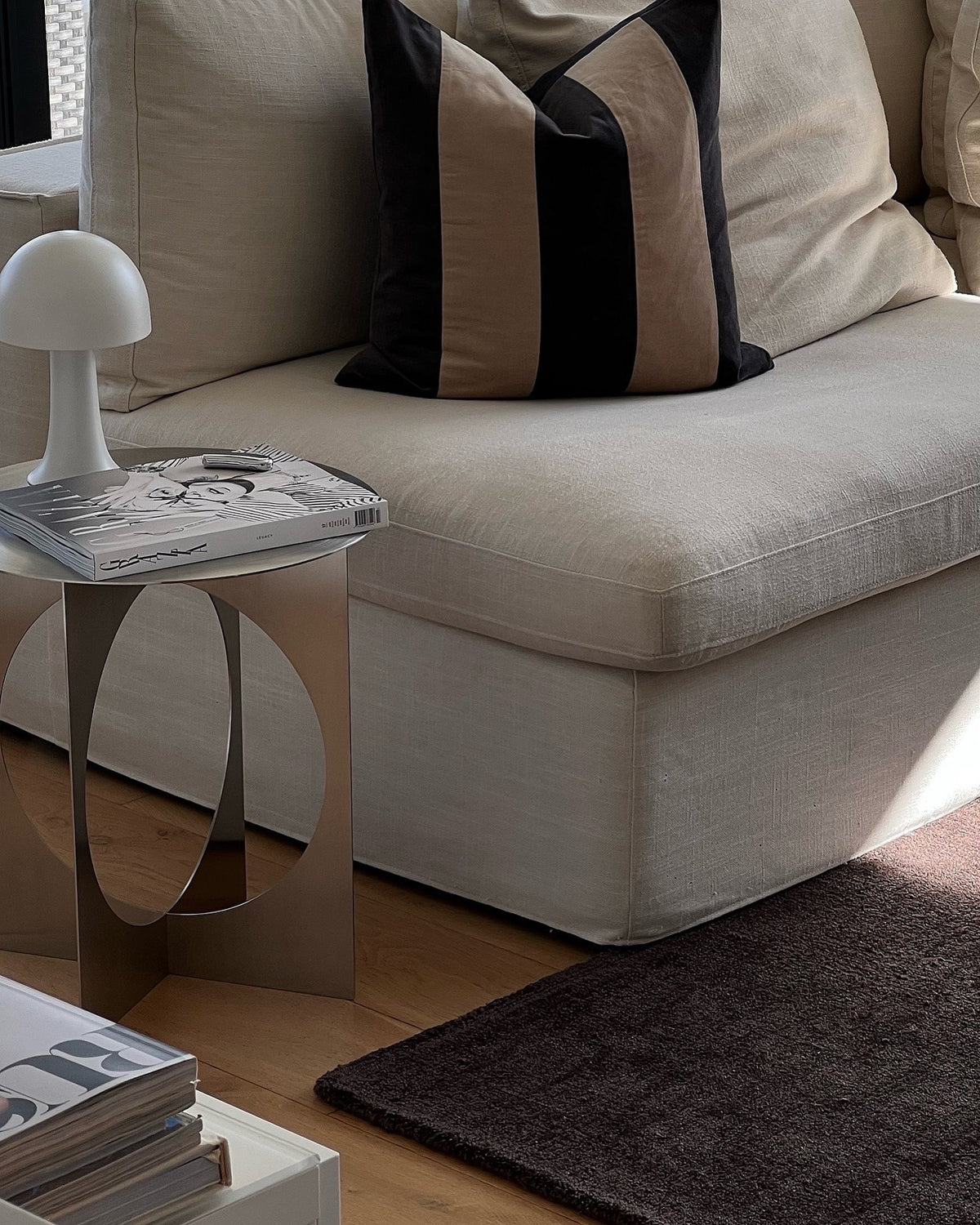 Stainless steel side table next to a sofa