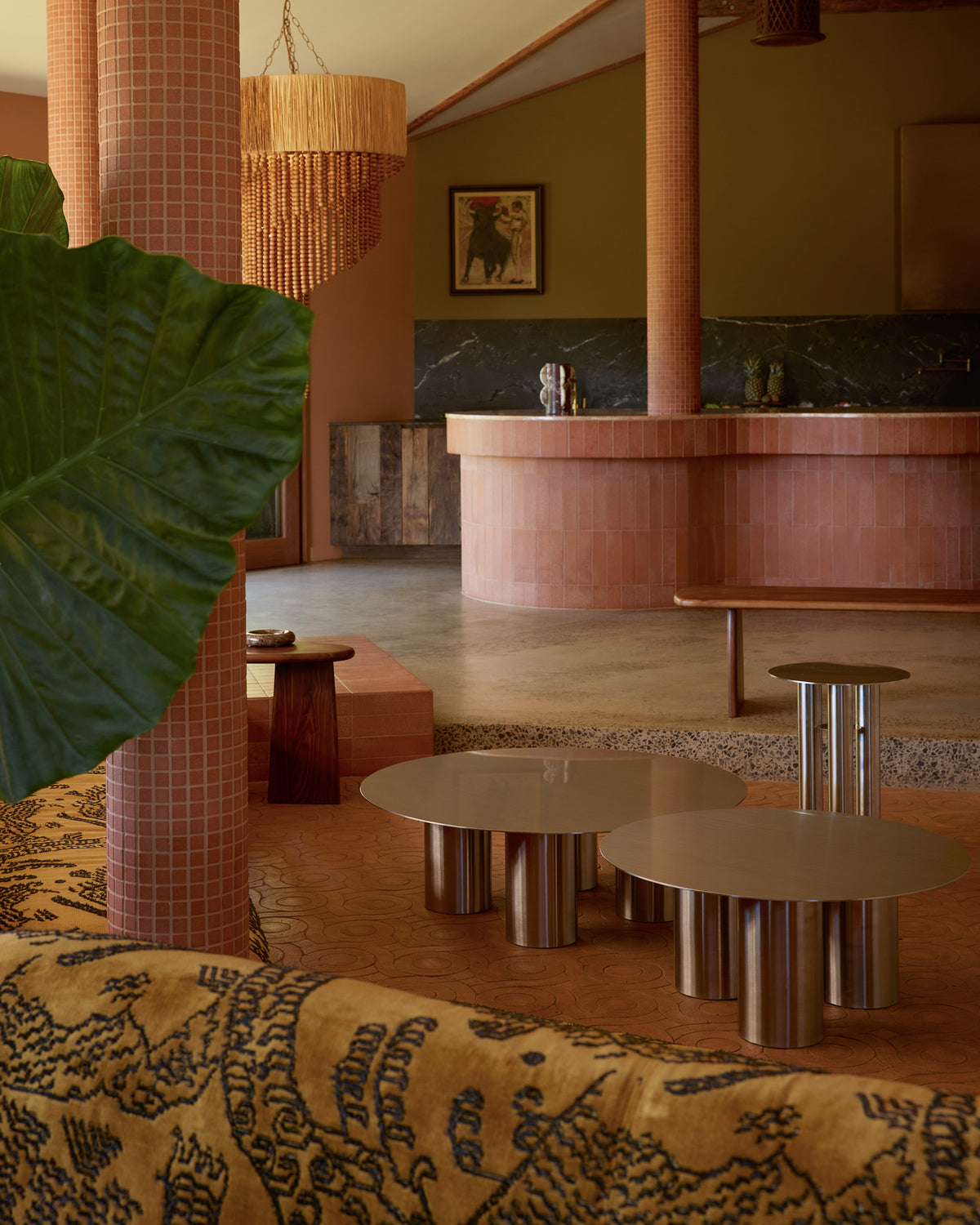 Modern interior design with wooden furniture, greenery, and a chandelier.