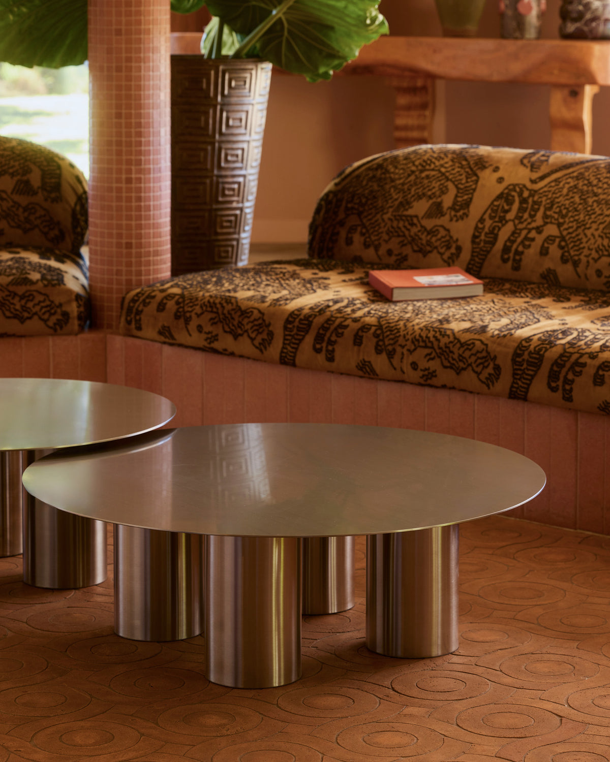 Modern living room with a patterned sofa and stainless steel coffee table.