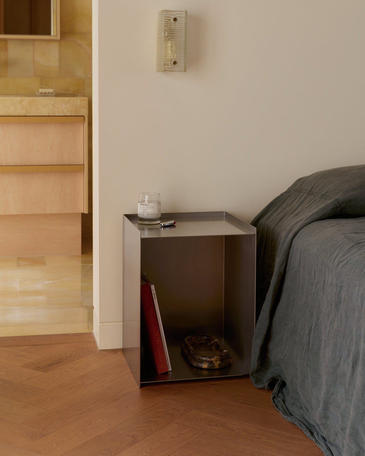 Stainless steel bedside table styled in a bedroom.