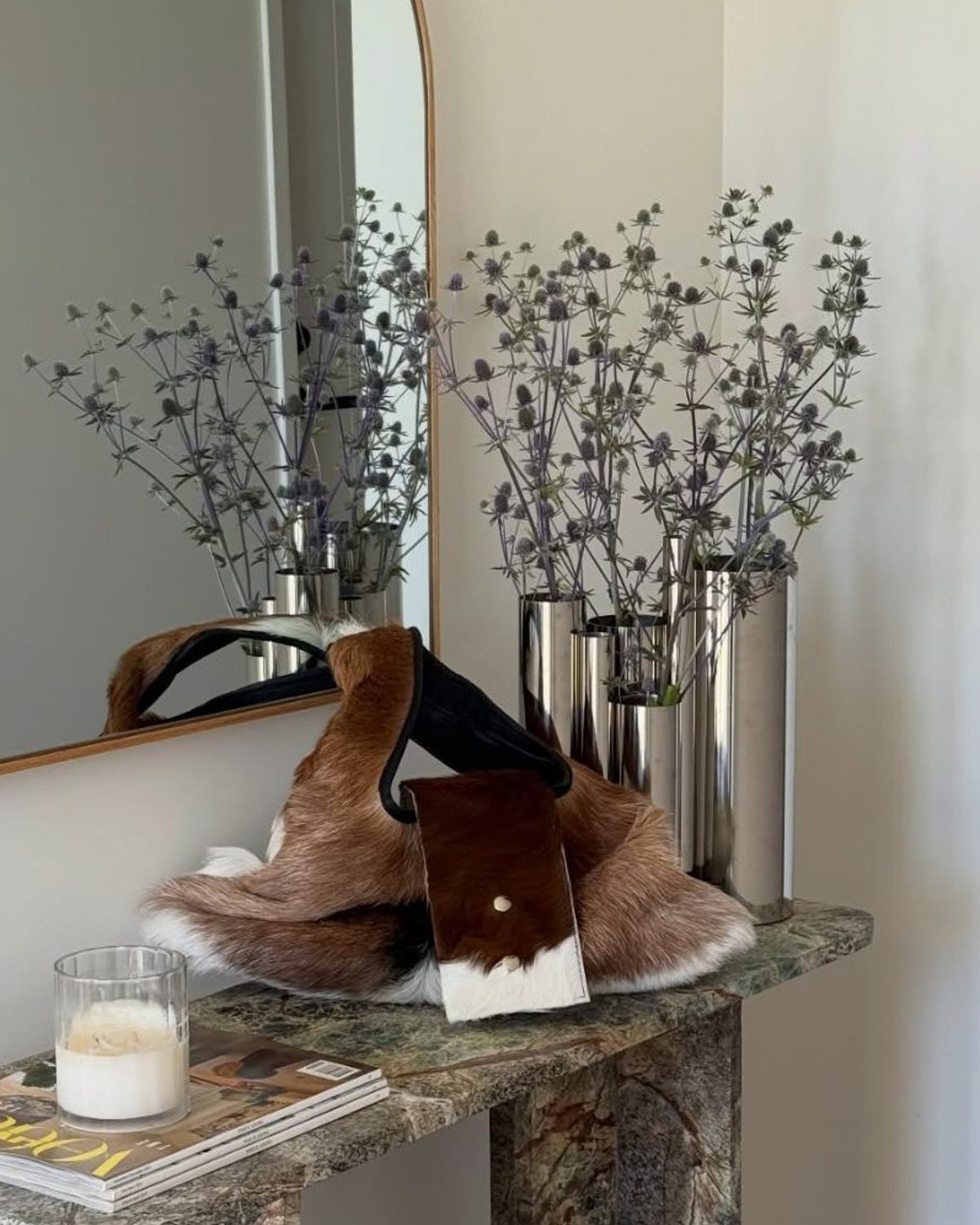 Entryway console styled with a chrome vase