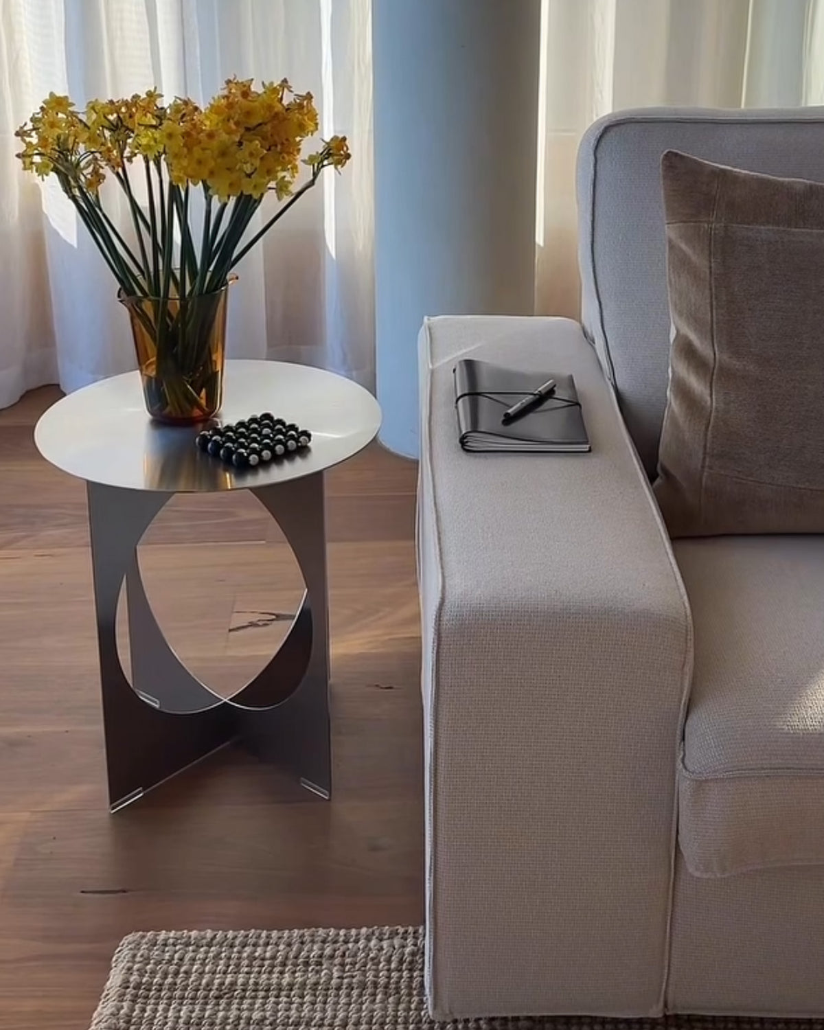 Stainless steel side table next to a sofa